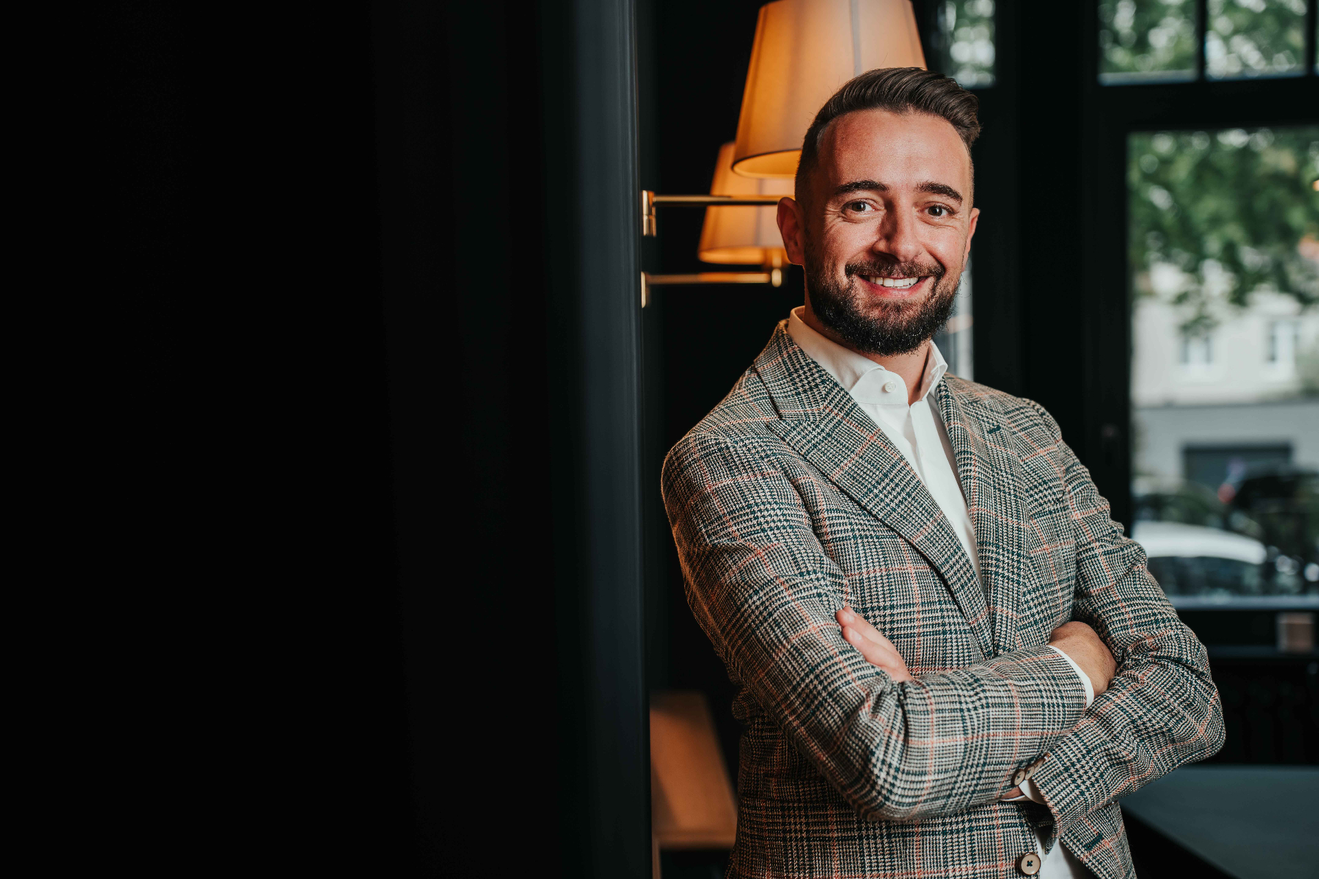 Fabio Lavalle, co-fondateur de Pixel Passion × Vidéo Passion, en veste prince-de-galles, bras croisés, dans une ambiance cinématographique